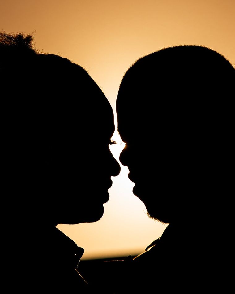 Silhouettes de deux mariés face à face au coucher du soleil