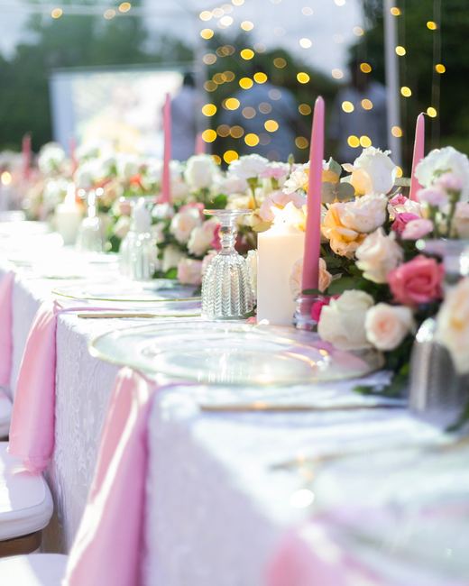 Bougies roses et roses pâles sur une table de réception